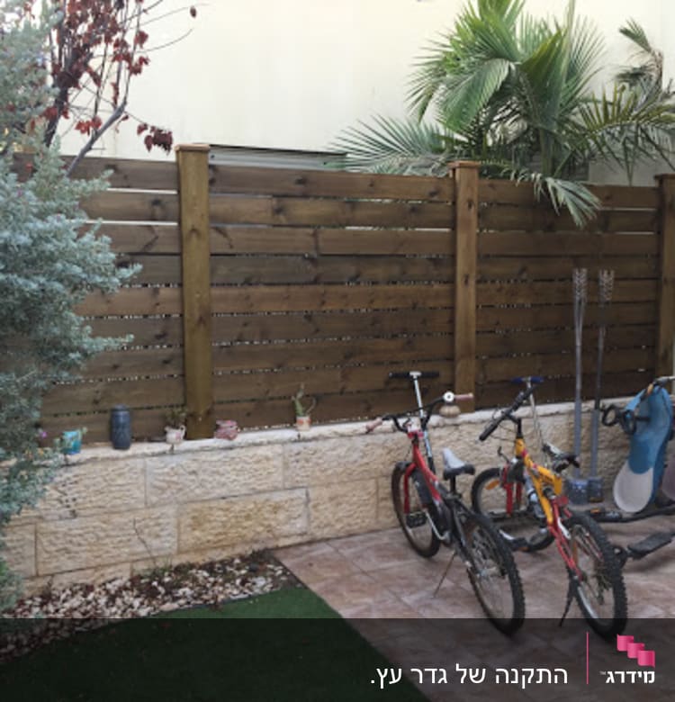 גדר עץ חומה עם עציצים קטנים על הקיר